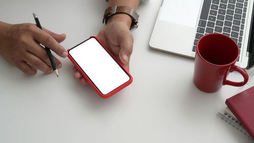 Midsection of man using laptop on table