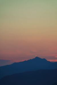 Scenic view of silhouette mountains against romantic sky at sunset