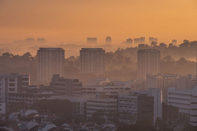 High angle view of buildings in city during sunset