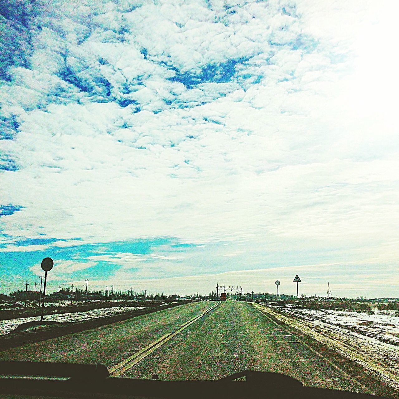 RAILROAD TRACK AGAINST CLOUDY SKY