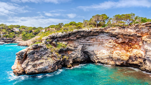 Rock formations by sea against sky