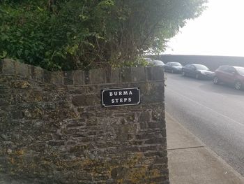 Information sign on wall by road