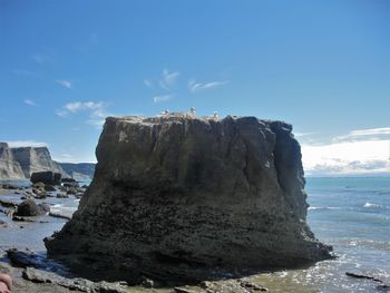 Rock formations by sea against sky