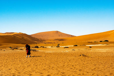 Full length of man on desert against clear sky