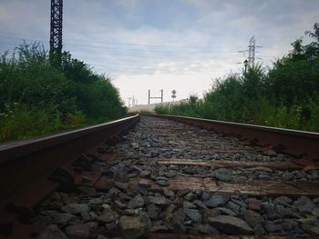 Railroad track amidst trees against sky