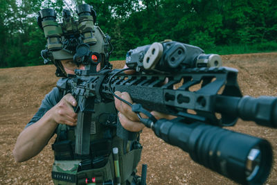 Full length of man holding camera while sitting on land