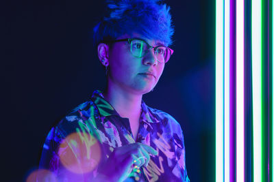 Portrait of young man against black background