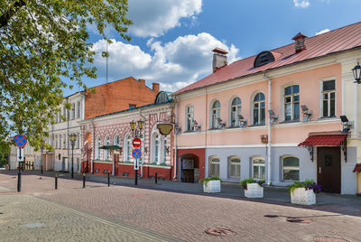 Houses by street in town against sky