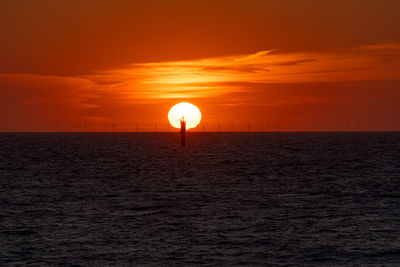 Scenic view of sea against orange sky