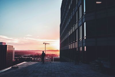 People walking in city at sunset