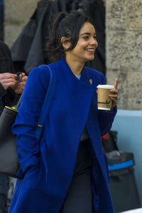 Smiling young woman using smart phone outdoors