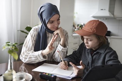 Mother helping son with homework at home