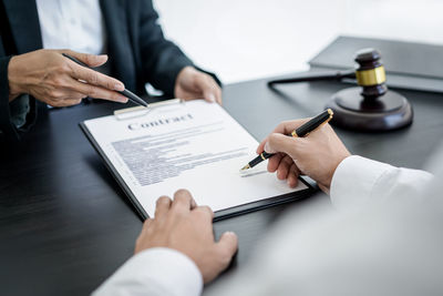 Midsection of lawyer working on table