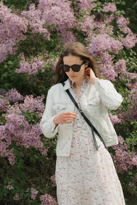 Young woman standing against plants