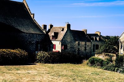 Old house on field against sky