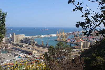 High angle view of city by sea against clear sky