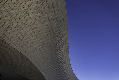 Low angle view of modern building against clear blue sky