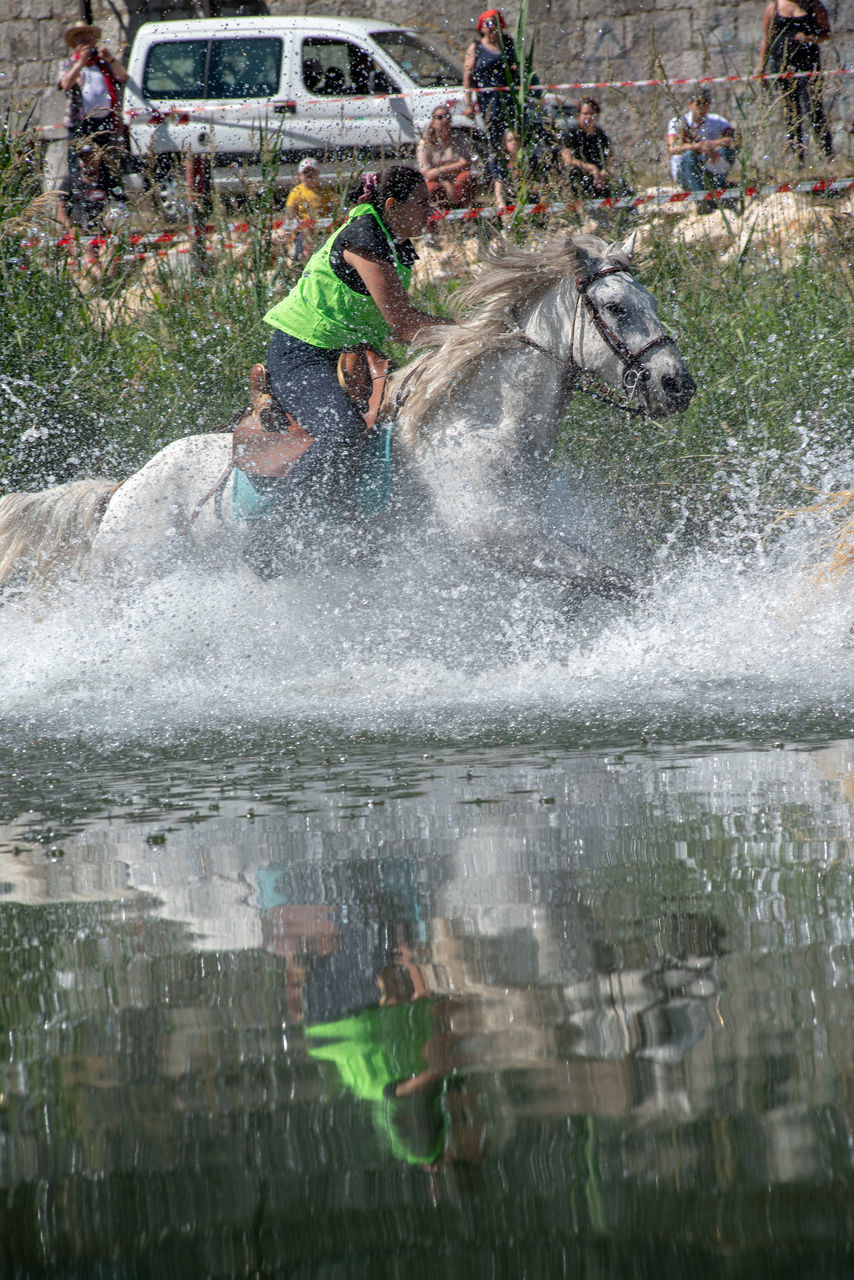 PEOPLE AT WATER SPLASHING IN PARK