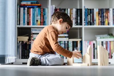 Side view of boy sitting on book