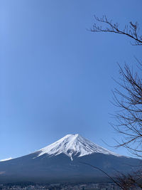 Scenic view of snowcapped mountains against clear blue sky