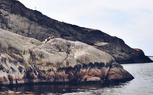 Woman lying on rock by sea