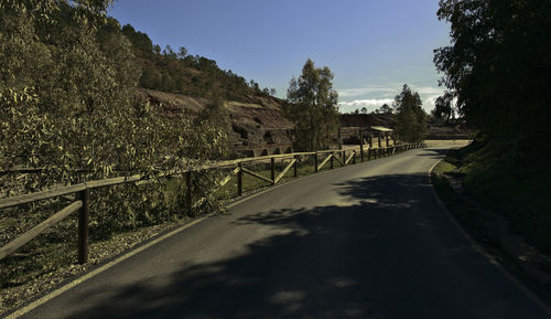 Road amidst trees against sky