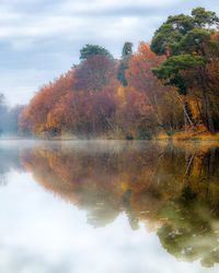 Reflection of trees in lake against sky during autumn