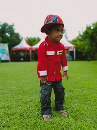 Full length of cute boy standing on grassy field