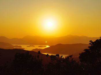 Scenic view of silhouette mountains against romantic sky at sunset