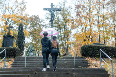 Rear view of couple walking on staircase