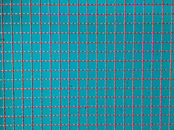 Full frame shot of metal grate against blue wall