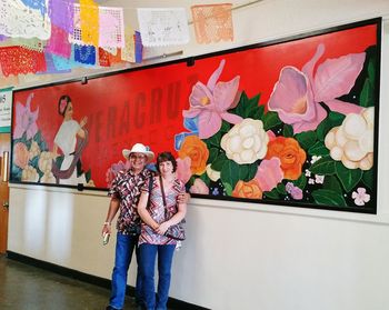 Full length of woman holding multi colored standing against wall