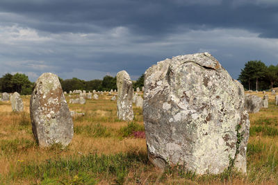 Stone wall on field against sky