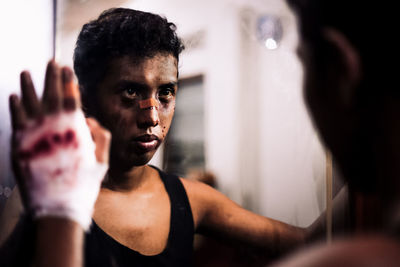 Reflection of man with injured face in mirror