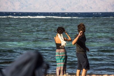 Rear view of women standing in sea