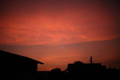 Low angle view of silhouette buildings against sky during sunset. orange sky in the evening. 