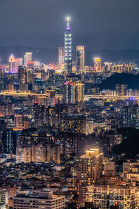 Illuminated cityscape against sky at night
