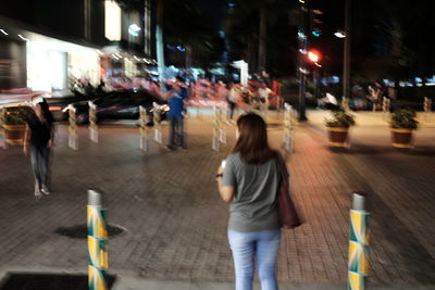 Woman walking on road at night