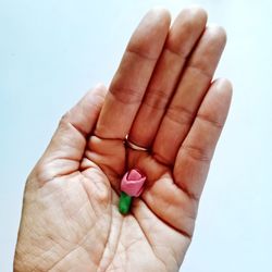 Cropped hand holding clay over white background