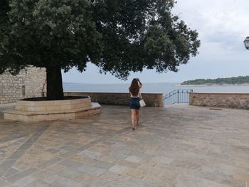 Woman standing by sea 