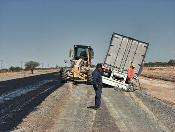 People working on street against clear sky