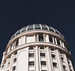 Low angle view of illuminated building against clear sky at night