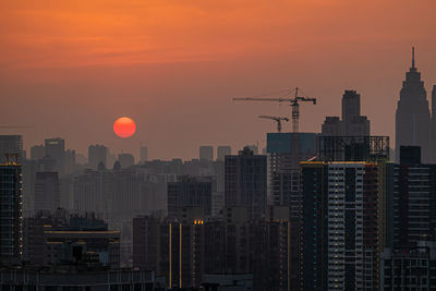 Modern buildings against sky during sunset