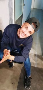 High angle portrait of smiling young man sitting at home