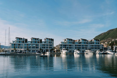 Buildings by river against sky