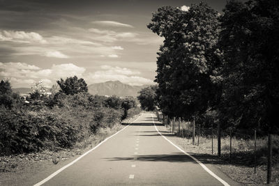 Road amidst trees against sky