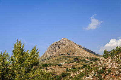 Built structure on landscape against blue sky