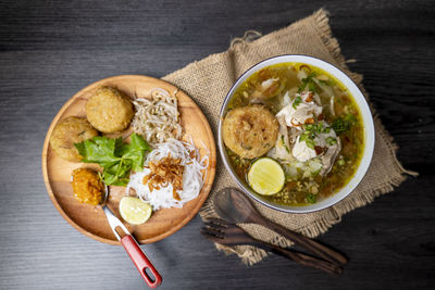 Soto ayam, indonesian food, photographed high angle view decorated with cutlery