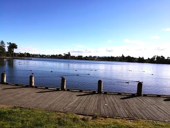 Pier over river against blue sky