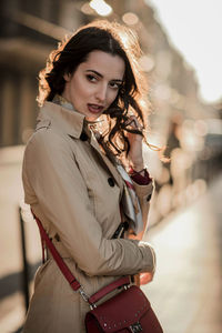 Fashionable woman standing against building in city